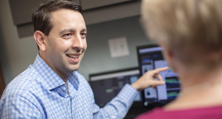 Dr. Ryan Tarantola with a patient pointing to screen